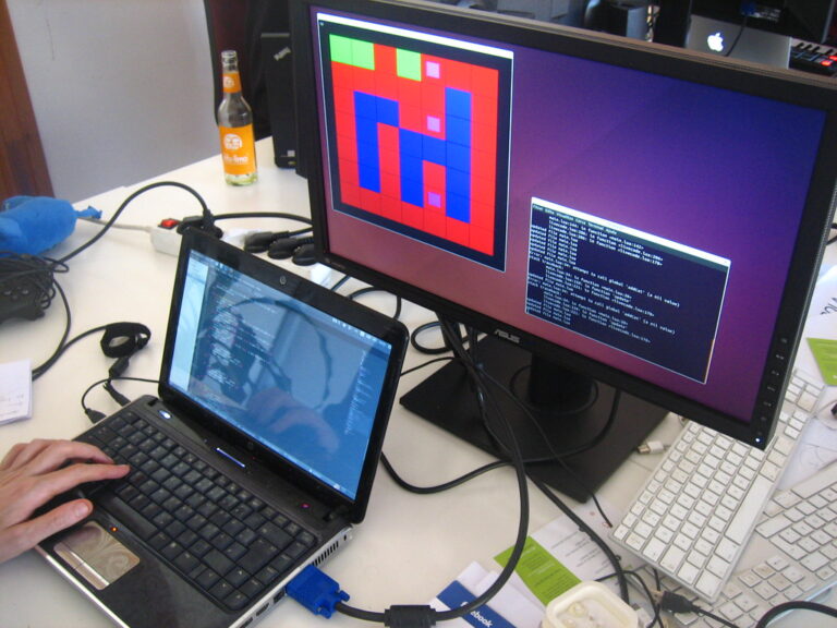 Programador trabajando con una laptop y código en pantalla